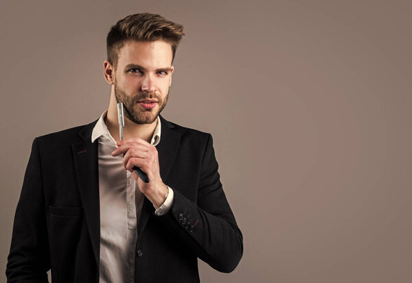 young handsome guy in suit hold razor blade. male barber master with tool. bearded man with business look. fashion and beauty. barbershop concept. mens hair styling and grooming