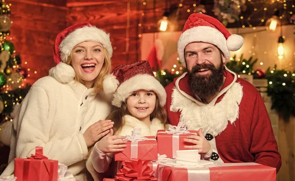 Noel 'de. Baba ve anne kızı sever. Xmas hediye kutuları. Hediyeni aç. Noel Baba şapkalı küçük bir çocuk ve ailesi. Kış tatili Alışveriş satışları. Mutlu aile yeni yılı kutluyor. — Stok fotoğraf