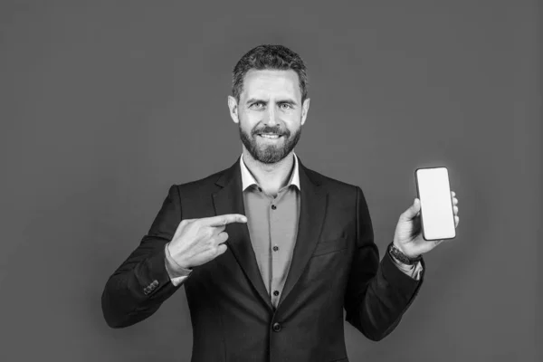 Bell'uomo in abbigliamento business alla moda che punta il dito sul telefono, annuncio — Foto Stock