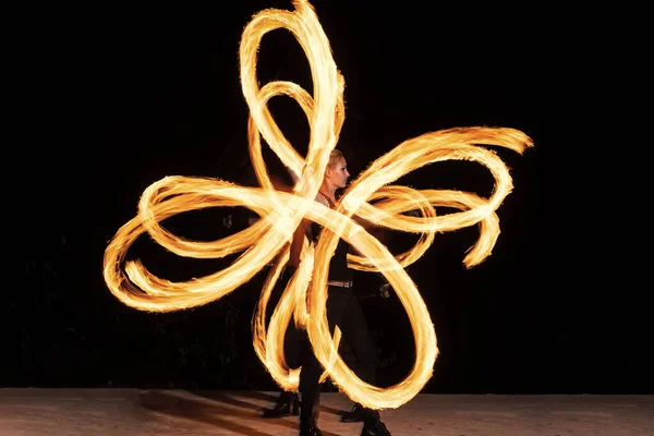 Sexy mujer artista realizar ardiente twirly senderos por spinning flaming pois durante fuego rendimiento —  Fotos de Stock