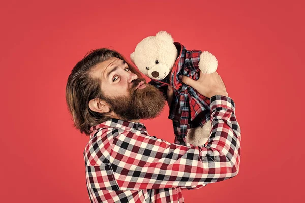 Brutal barbudo hombre desgaste a cuadros camisa tener exuberante barba y bigote beso peluche oso juguete, amor —  Fotos de Stock