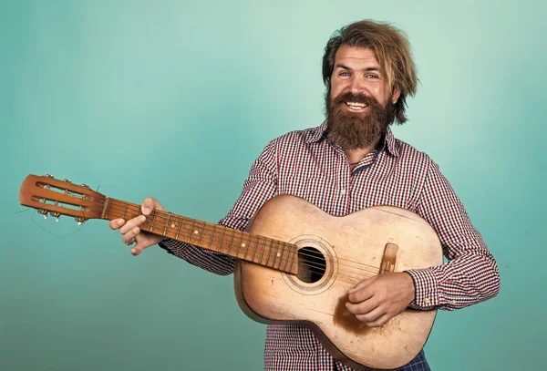 Sonrisa feliz. concepto de música y vocal. hombre tocando la guitarra acústica. hombre brutal con bigote y barba sostener la guitarra. tienda de música. Barbudo siendo una estrella de rock. guitarrista masculino casual —  Fotos de Stock