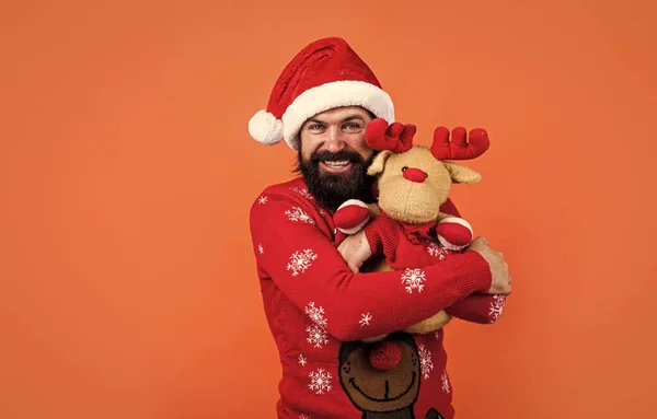 산타 클라우스 모자를 쓰고 뜨개질을 한 행복 한 남자 크리스마스 선물인 크리스마스 연휴를 축하하는 장난감 스웨터를 입고 있다. — 스톡 사진