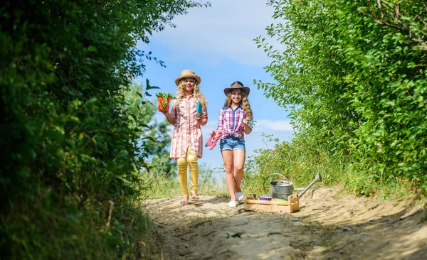 Florista no trabalho. agricultura e agricultura. lado do país primavera. ecologia e protecção do ambiente. meninas pequenas agricultor na aldeia. crianças segurar ferramentas de jardinagem. Dia da Terra. fazenda família de verão — Fotografia de Stock