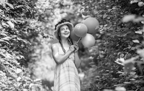 Dětská procházka v jarním parku nebo zahradě. malá holčička s letní růží v klobouku. letní dovolená a dovolená. ženskou krásu a módu. štěstí z dětství. šťastný kluk s balónky. Krásné zahradničení — Stock fotografie