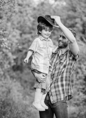 Çocuk eğleniyor kovboy baba. Çiftlik ailesi. Ebeveyn çiftliğinde tatiller. Büyüyen sevimli kovboy. Hafta sonu çiftlikte. Küçük çocuk ve baba doğa arka plan. Macera ruhu. Bahçede küçük yardımcı