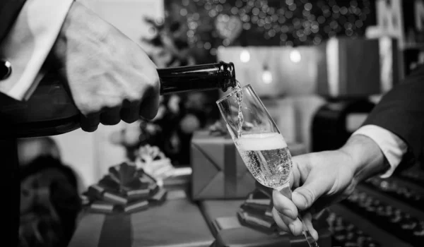 Mani versando champagne in eleganti decorazioni natalizie in vetro sfondo. All'ultimo minuto prima del nuovo anno. Bevi champagne o spumante. Festeggia il nuovo anno con lo champagne. Il concetto di salute — Foto Stock