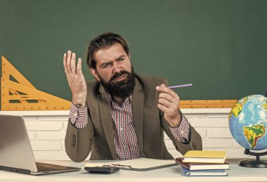 Mürekkebim bitti. Bilgisayarda sakallı kafası karışmış bir adam. İnternette çalışıyorum. gayri resmi eğitim. Erkek öğrenci derste karatahta ile sınıfta oturuyor. Sınavı geç. konu öğreniliyor