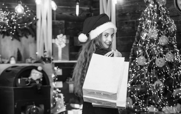 쇼핑하기. 애들 순록 스웨터 랑 산타 모자. 가족을 위한 쇼핑 패키지. 작은 상점 들락날락. 아이들은 종이봉투를 들고 미소짓습니다. 연휴 선물 쇼핑. 크리스마스가 왔네. 새해 겨울 방학 — 스톡 사진
