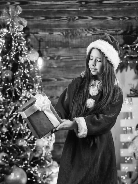 クリスマスにしたいのは。幸せと喜び。子供の幸せな興奮した女の子はクリスマスツリーの近くのギフトを見つける。メリークリスマス。幸せな子供時代のコンセプト。キッド・サンタ・ハット。サンタは贈り物を持ってきた。奇跡の時 — ストック写真