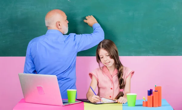 Σχολική οικογένεια. νέα τεχνολογία στη μάθηση. Μάθημα στο διαδίκτυο. Γράφω μια έκθεση. online εκπαίδευση. Πίσω στο σχολείο. ώριμη δασκάλα βοηθήσει κορίτσι του σχολείου. κοριτσάκι με δάσκαλο μελέτη για το laptop — Φωτογραφία Αρχείου