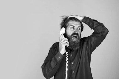 Oh hayır. Sakallı adam kırmızı gömlek giyer. Sıradan bir erkek telefonu. Sohbet konsepti. Adam sekreter ya da asistan retro telefonda konuşuyor. Telefonla konuşan acımasız bir adam. İletişim. Boşluğu kopyala