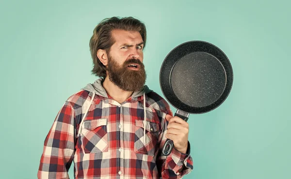 Hipster masculino con pelo peinado de moda y barba cocina con sartén, calidad — Foto de Stock