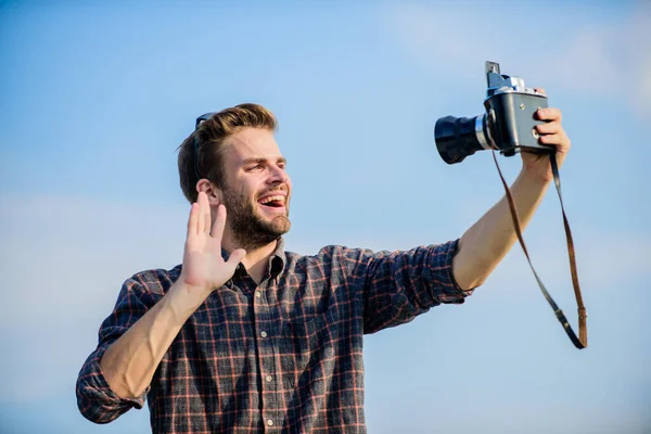 Blogger de viajes. Reportero tomando fotos. Equipo vintage. Blogger disparando vlog. Tiempo de vacaciones. Guapo blogger chico viajero cámara retro. Tipo al aire libre cielo azul de fondo. Concepto de fotoperiodista — Foto de Stock