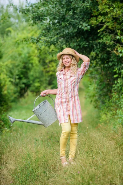 Watering plants in garden. Watering tools. Girl child hold watering can. Spring gardening checklist. Improve irrigation timing. Optimize water use. Measure soil water content temperature and salinity — Stock Photo, Image