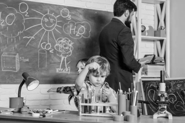 科学実験をする子供たち教育。化学研究室幸せな子供の先生。学校に戻る化学実験室で液体の実験を行う。自信に満ちた学生の勉強 — ストック写真