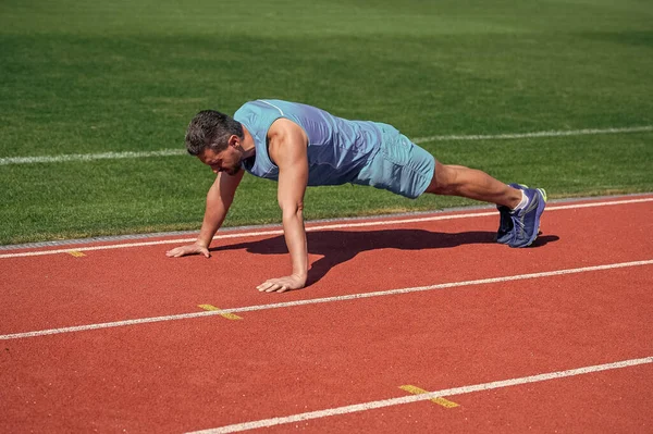 Kaslı adam tahtada durur spor antrenmanında şınav çeker, egzersiz yapar. — Stok fotoğraf