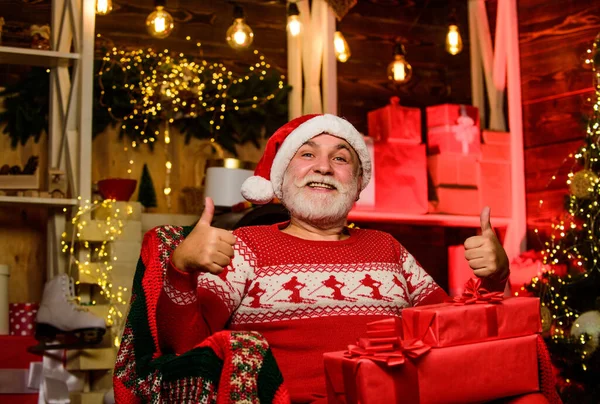 Старший бородатый Санта Клаус. Концепция традиций. Пожилой дедушка дома. Легенда о Санта-Клаусе. Счастливого Рождества. Доставка подарков. Подарки для семьи. Санта-Клаус расслабляется в кресле — стоковое фото