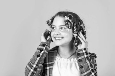 Güzel bir saç stili yap. Harika bir saç stili. Mutlu çocuk. Kuaför salonu. Mükemmel güzellik. Sarı arka planda saç tokası ve saç tokası olan bir kız. Saçlarının etrafında kıvırcık kızlar