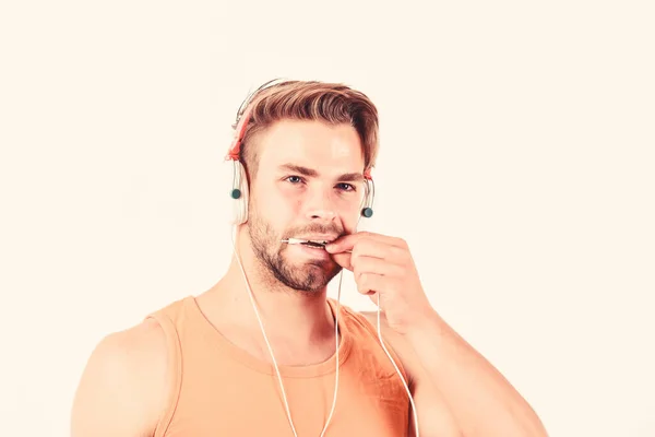 Беспроводная концепция Небритый мужчина слушает музыку в наушниках. сексуальный мускулистый мужчина слушает спортивную музыку. человек в наушниках изолирован на белом. Насладитесь музыкой — стоковое фото