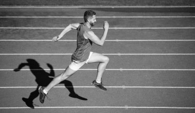Egzersiz rutini. Meydan okuma ve rekabet. Maraton hızı. Sporcu sporcu kazanmak için hızlı koşar. Başarılı fitness koşucusu. Stadyumdaki koşu pistinde erkek koç. Dayanıklılık ve dayanıklılık. Yarış pistinde koşucu