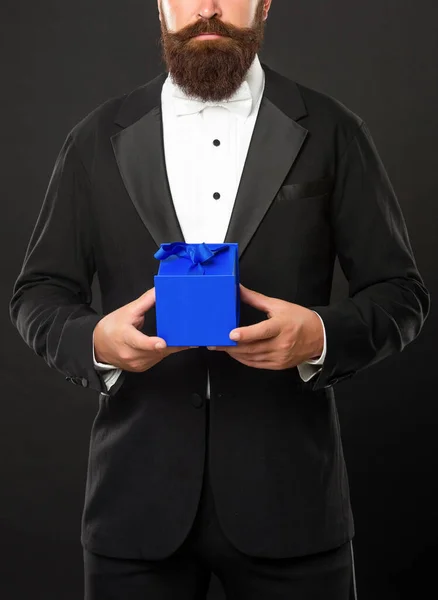 Hombre barbudo recortado en esmoquin celebrar presente caja, compras — Foto de Stock