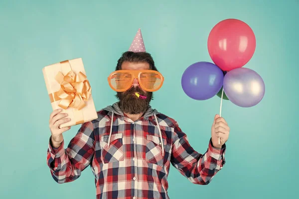 Cyber-Montag. Alles Gute zum Geburtstag. Männerweihnachtsfeier. bärtiger Typ mit Party-Luftballons und Geschenkbox. Der unrasierte brutale Mann mit Bart feiert geschäftlichen Erfolg. Ausdruck puren Glücks — Stockfoto