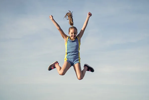 Χαρούμενο παιδί στον αθλητισμό ρούχα κατάρτισης άλμα υπαίθρια, ευτυχία — Φωτογραφία Αρχείου