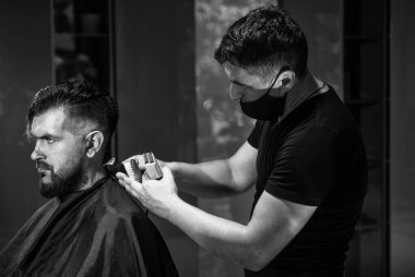 Usta Barber saç stilini ve saç stilini elektrikli traş makinesiyle yapıyor.