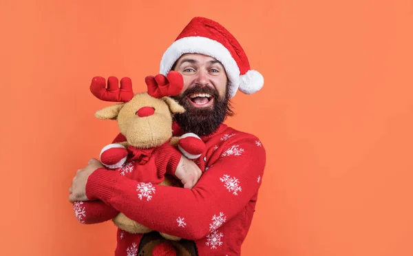 Šťastný vousatý muž v Santa Claus klobouk a svetr se sobí hračkou oslavit zimní dovolenou vánoční a cítit veselé o vánoční dárky, Nový rok radost — Stock fotografie