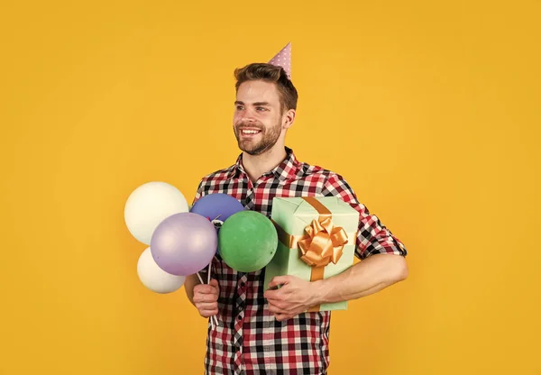 Man med fashionabla preparerat hår och skägg hålla ballonger och låda, födelsedag — Stockfoto