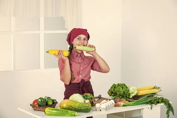 Füttern Sie Ihre Träume. Kind mit Kochmütze verspürt Hunger. Mädchen in der Küche. gesunde biologische Lebensmittel. — Stockfoto