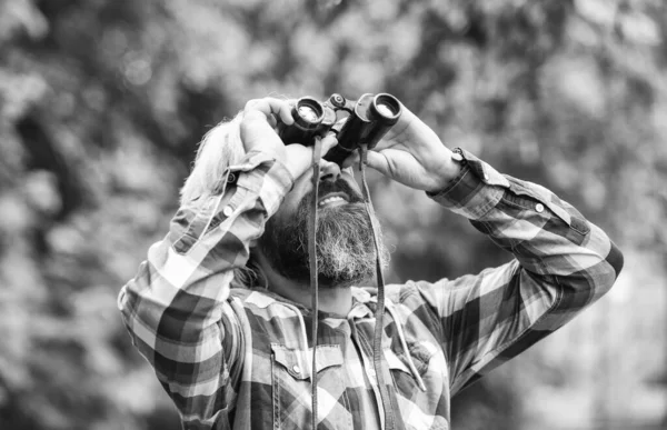 O tipo explora o ambiente. Turismo férias de verão. Passatempo e lazer. Observando a natureza. Expedição de ornitologia masculina na floresta. Homem observando a natureza. Hipster turista detém binóculos natureza fundo — Fotografia de Stock