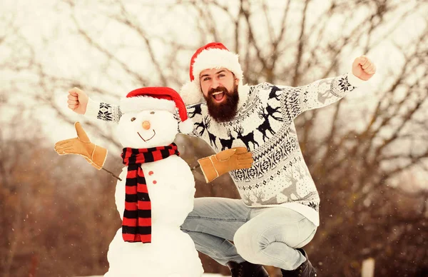 Bartträger bauen Schneemänner. glücklich Hipster bereit, Weihnachten zu feiern. Aktivität in der Wintersaison. Mann Weihnachtsmann spielt mit Schnee. Winterurlaub im Freien. warmer Pullover bei kaltem Wetter. Weihnachten — Stockfoto