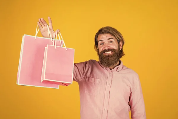 Bela compra. surpresa de aniversário na festa. homem com pacote. Preparem-se para férias. melhor oferta de venda. homem barbudo feliz com pacote presente. alegre hipster brutal segurar presente. saco de compras de papel — Fotografia de Stock