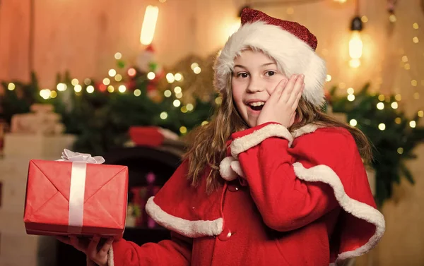 La Navidad es tiempo de dar. Santa Claus niña. Presente de compras. Niña elfa. Regalo navideño. Niña con sombrero rojo. Regalo de vacaciones. En Navidad. Caja de regalo. Feliz año nuevo. Regalo para ti —  Fotos de Stock