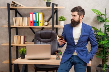 Ofiste cep telefonu kullanan profesyonel bir adam, iş adamı