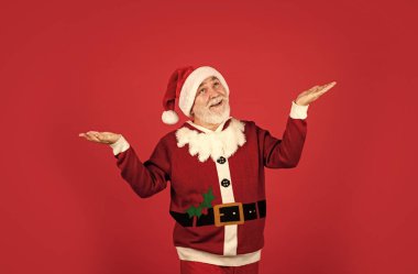 İçtenlikle tebrik ederim. Kırmızı arka planda şapkalı, sakallı Noel Baba. Noel hediyesi ve hediye alışveriş zamanı. Kış tatili eğlencesi. Noel Baba kostümlü komik son sınıf öğrencisi. Mutlu yıllar 2021. Mutlu Noeller.