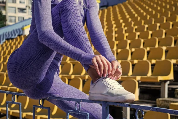 Athletische Frau im Fitnessanzug Krawattenschnürsenkel am Stadion, Sportbekleidung — Stockfoto