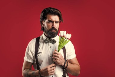 Vahşi sakallı adam elinde güzel bir çiçek buketi tutuyor taze laleler, babalar günü