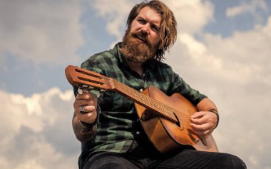 Benim dünyam burası. Olgun karizmatik erkek gitarist. Sakallı ve bıyıklı adam gitar çalıyor. Kareli gömlekli sakallı adam şarkı söylüyor. Müzisyen müzisyen. müzik teli enstrümanı