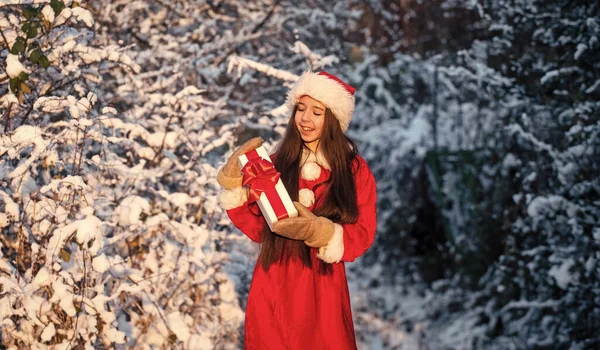 Noel Baba 'dan hediyeler. Frosty noel sabahı. Mucize zamanı. Cömert Noel Baba. Çocuk mutlu kız dışarıda karlı doğada. Mutlu noeller. Mutlu çocukluk kavramı. Mutluluk ve neşe. Çocuk Noel Baba şapkası. — Stok fotoğraf