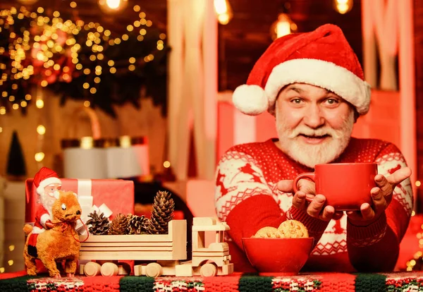 髭の男はクッキーを食べる冬休み気分サンタは夕食をサンタのためにおじいちゃん牛乳飲んでクリスマスの構図。新年会の準備はいいか?クリスマスパーティーのお祝い今こそ — ストック写真