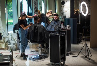 Sabah rutini. Bıyıklı vahşi hippi yeni saç stili yapıyor. Berber dükkanı. Erkek saç stili. Tıraş bıçağıyla mükemmel saç kesimi. Berber ustası saç kesti. Kuaförde sakallı, olgun bir hippi.