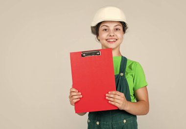 Çocuk inşaat alanında kask takıyor. İnşaat işleri yapan genç bir inşaatçı kız. Çocuk tamir işiyle uğraşıyor. Atölyede yenileme konsepti. Meşgul profesyonel marangoz. İnşaat mühendisi mimar