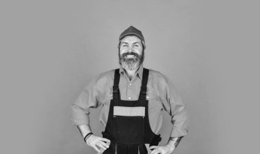 Adam liilersuit giyiyor. Tulumlu sakallı işçi. Kendine güvenen bir tamirci. Tamircinin Portresi. Depoda çalışan bir işçi. Kafkasyalı işçiler depoda. Çılgın tamirci konsepti