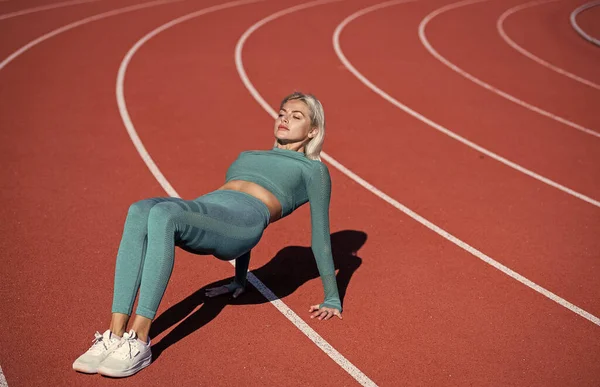 Sexy fitness vrouw stretching en training kern spieren in sportkleding op het stadion, harworking — Stockfoto