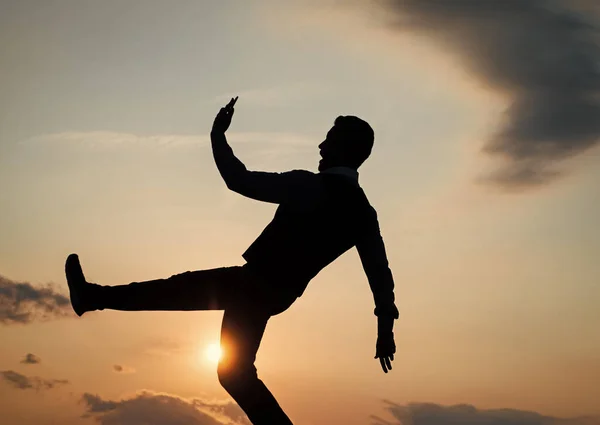 Силуэт парня, делающего шаг в смысле свободы на небе восхода солнца, будущее — стоковое фото