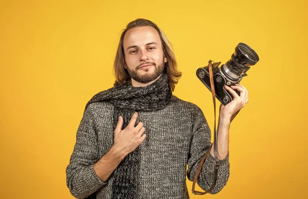 긴 머리에 사진 카메라를 들고 있는 사진사는 뜨개질 스웨터와 목도리를 착용하고 사진을 찍는다 — 스톡 사진
