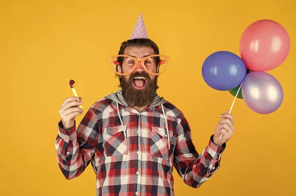 Havalı saç stili olan şık sakallı adam kareli gömlek giyiyor parti balonları tutuyor, eğleniyor. — Stok fotoğraf